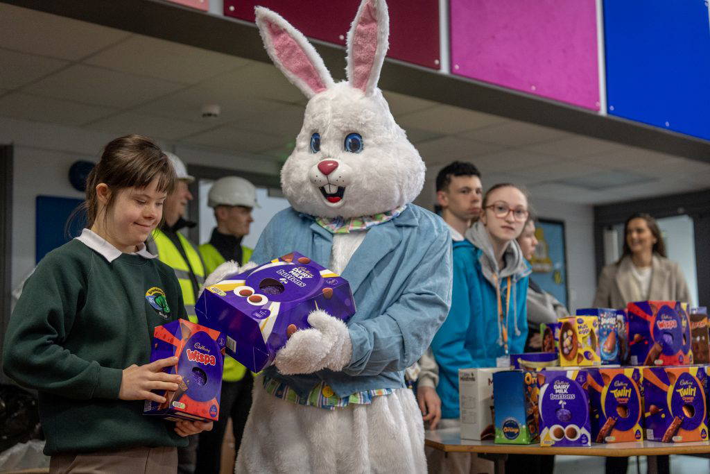 Easter Bunny handing an Easter egg to a young girl at Hilltop Primary School